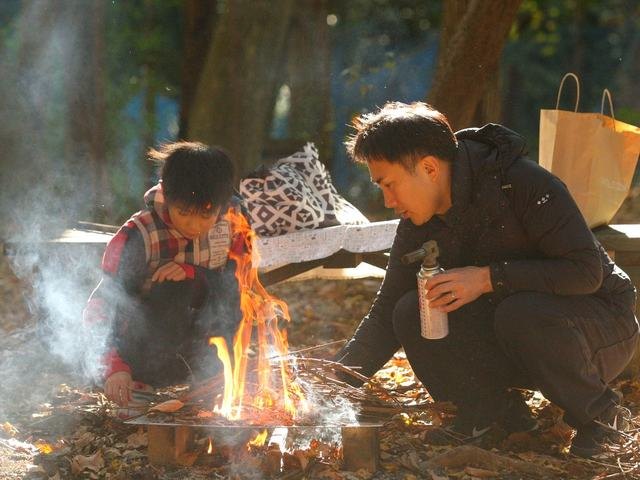 焚き火で火をおこす2人