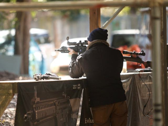 スコープ付きの銃で的を狙う参加者