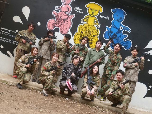 壁画の前に並ぶサバゲー参加者の集合写真