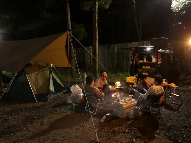 タープの下で夜を過ごすグループ