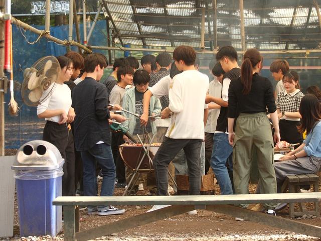 BBQコンロを囲む大人数のグループ